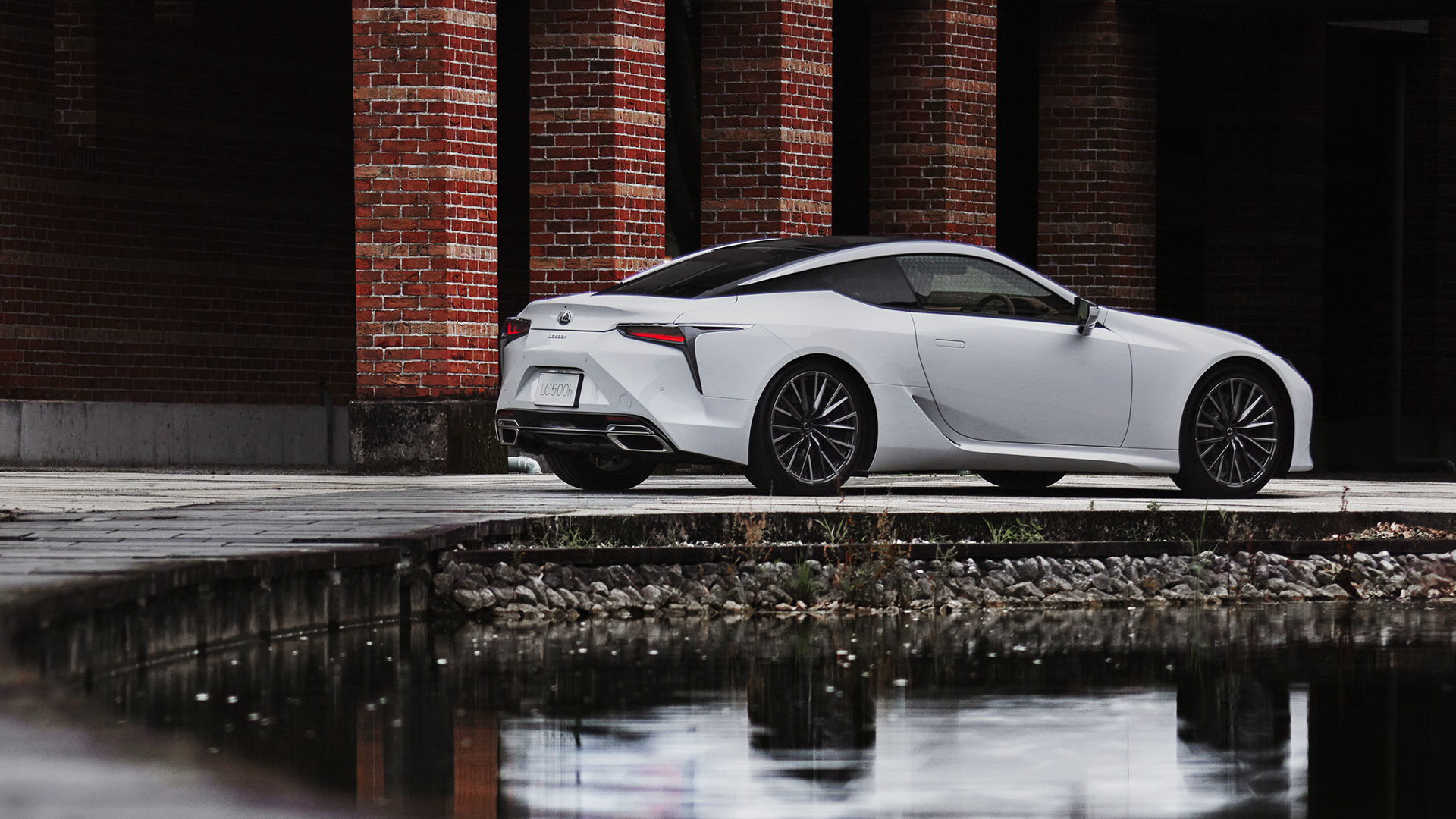 A white Lexus LC Coupe parked with a body of water in the foreground